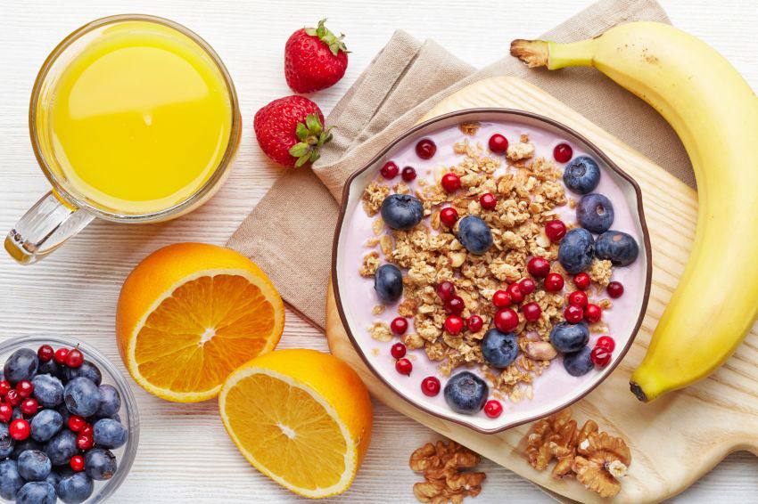 A bowl of cereal surrounded by other healthy food